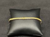 a black pillow with a gold bracelet on it