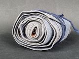 a close up of a rolled up blue towel on a gray surface