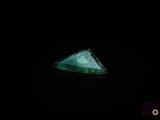 l'image d'un diamant vert de forme triangulaire dans l'obscurité