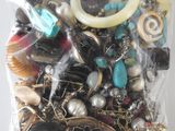 a bag of assorted jewelry on a white surface