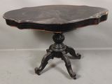 une image représentant une table avec un plateau noir et un piètement en bois
