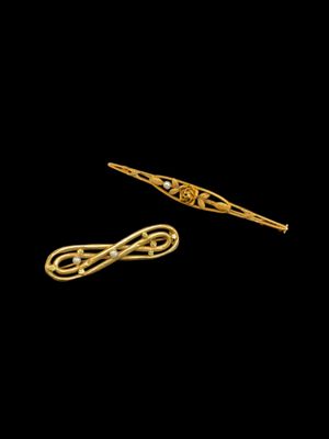 une paire de barrettes plaquées or ornées d'un motif en nœud