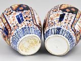 two blue and white vases with designs on them sitting on a table