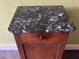 a small cabinet with a marble top on a carpeted floor