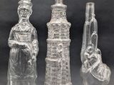three glass figurines of different sizes and shapes on a black background