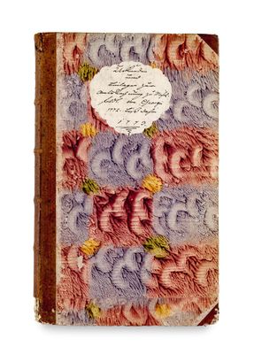 an old book with a picture of flowers and writing on it