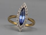 a close up of a gold ring with a blue stone in it