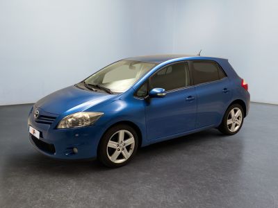 La Toyota Yaris bleue est garée dans une grande pièce.