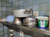 many pots and pans sitting on a shelf in the kitchen
