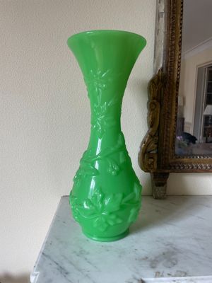 un vase vert posé sur une table en marbre