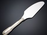 a silver cake knife with a handle on a black surface