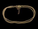 gros plan d'un collier en or sur fond noir