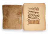 an open book with arabic writing on it sitting on top of a white surface