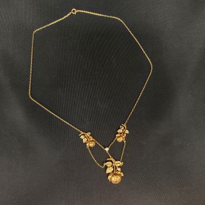 un collier en or orné de fleurs et de feuilles