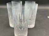 four clear glasses sitting on top of a table next to each other