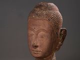 two statues of buddhas are sitting on a white surface