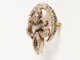 a close up of a gold and diamond ring on a white surface