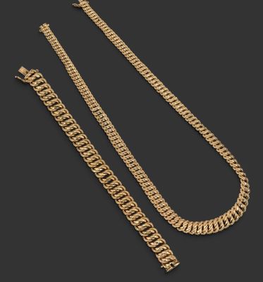 un ensemble composé d'un collier et d'un bracelet en chaîne dorée sur fond noir
