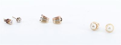trois paires de boucles d'oreilles et une boucle d'oreille en perle posées sur un fond blanc
