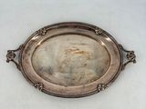 une assiette ancienne en argent sur laquelle est représentée une femme
