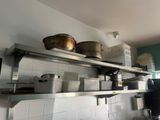 many pots and pans on the shelves in the kitchen