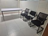 three chairs and a table in the corner of a room