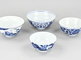 three blue and white bowls and a bowl on a table