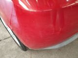 a close up of a red car ' s front bumper