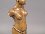 statue of a woman with a small breast on a wooden base