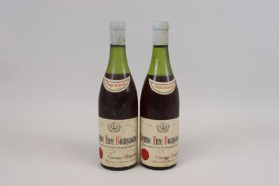 two bottles of wine sitting next to each other on a white surface