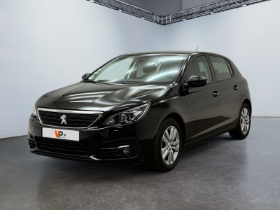the black car is parked in a large room with white walls