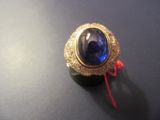 a close up of a ring with a blue stone in it