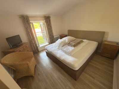 a bedroom with a bed and a chair in it