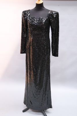 robe de soirée noire à paillettes et à manches longues, présentée sur un mannequin de vitrine