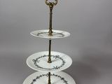 three tiered cake stand with three plates on top of it