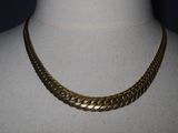 a close up of a gold necklace on a mannequin mannequin