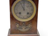 une horloge en bois posée sur une surface blanche