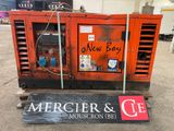 un gros générateur orange posé sur une palette