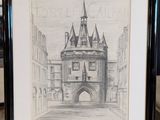 un vieux dessin représentant un château, encadré et posé sur une table