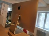 an apple computer sitting on a desk in a room