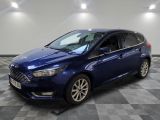 Une Ford Focus bleue est garée dans une pièce dont le sol est en damier.