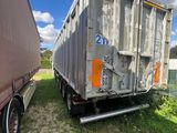 two semi trailers parked next to each other on the grass