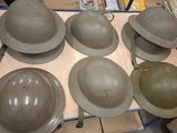 six helmets sitting on a table in a room