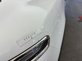 a close up of a white car with a sticker on it ' s hood