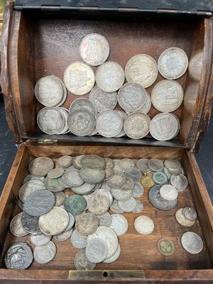 une boîte en bois remplie de pièces, posée par terre