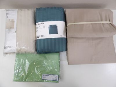 four sheets and a pillow on a white table