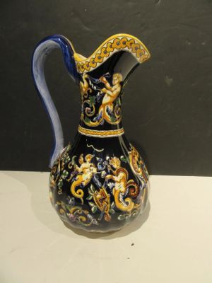 un vase bleu et jaune posé sur une table blanche