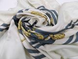 a close up of a white and blue striped scarf with gold accents