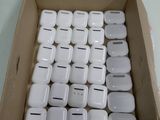 une boîte remplie d'AirPods blancs en forme de pomme posée sur une table