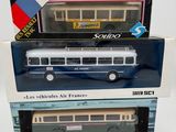 trois maquettes de bus dans leur boîte sont empilées les unes sur les autres